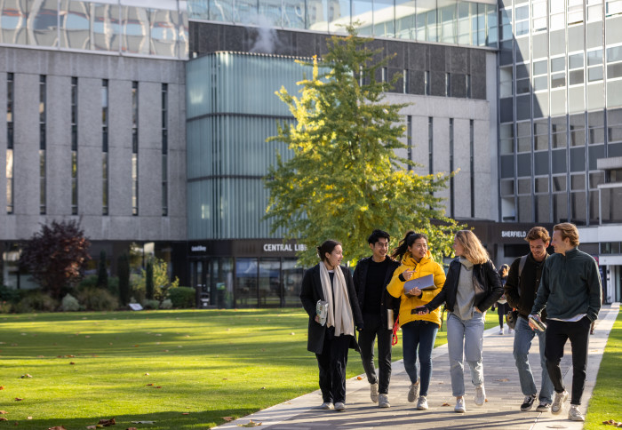 A group of students walking across the Dangoor Plaza at the South Kensington Campus