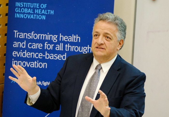 Image of Noubar Afeyan speaking in front of Institute of Global Health Innovation banner