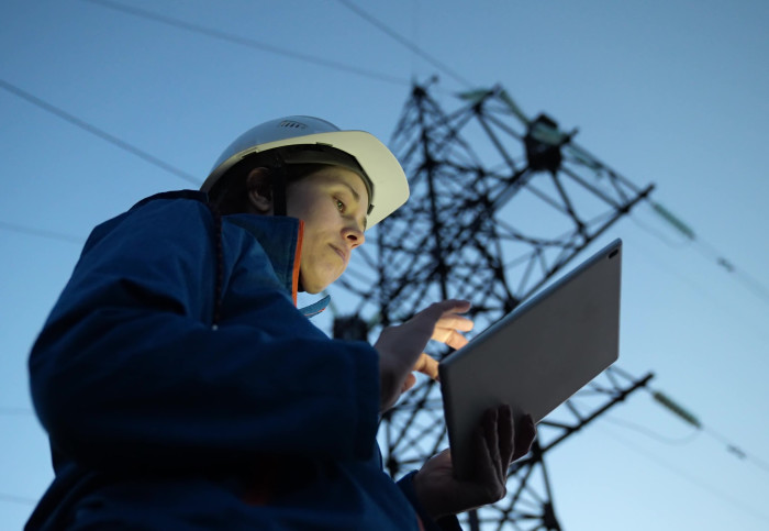 Woman engineer surveying power lines