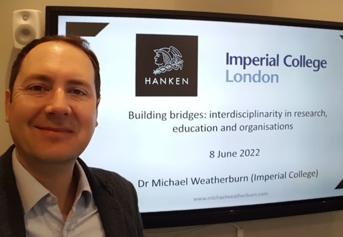 Michael Weatherburn in front of display screen at Hanken School of Economics