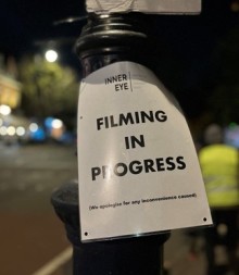 Sign on lamp-post says "Filming in progress"