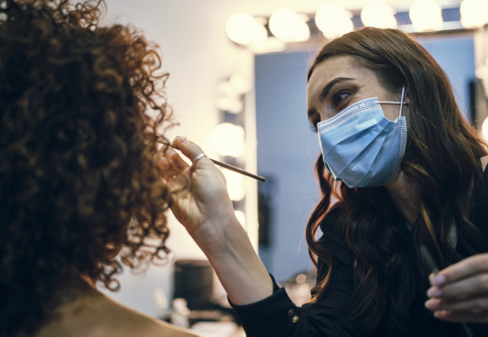 a make-up artist at work wearing a face mask