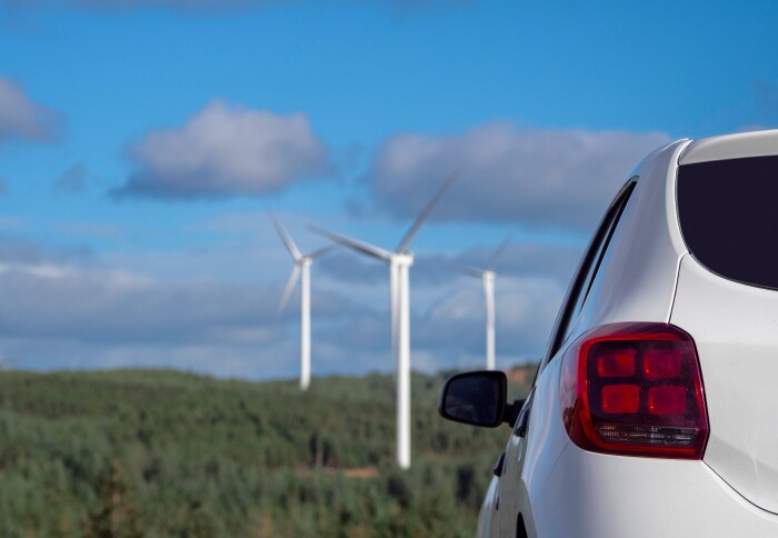 Car driving by wind turbines