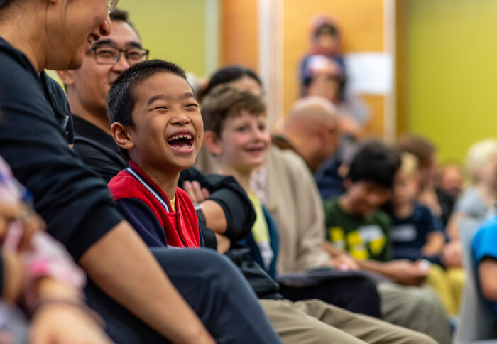 A scientist demonstrating an experiment to a captive audience mostly made up of children