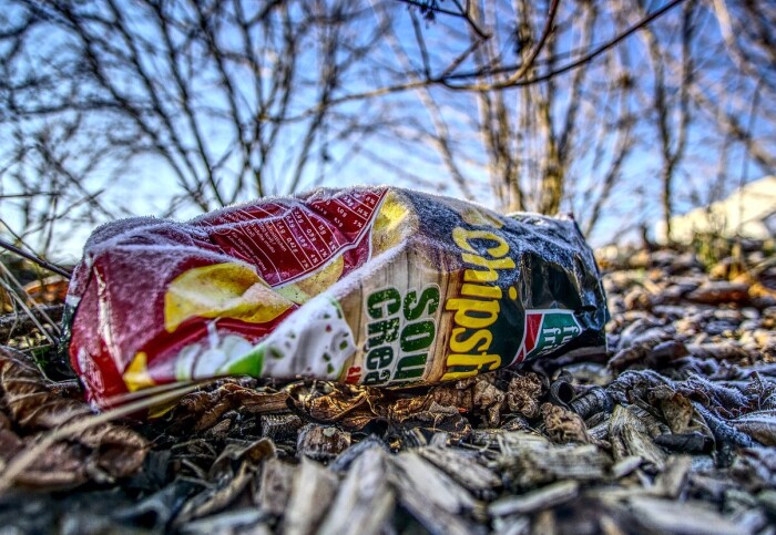 An empty crisp packet lying on the frosty ground under some trees. Credit: Markus Distelrath/Pixabay