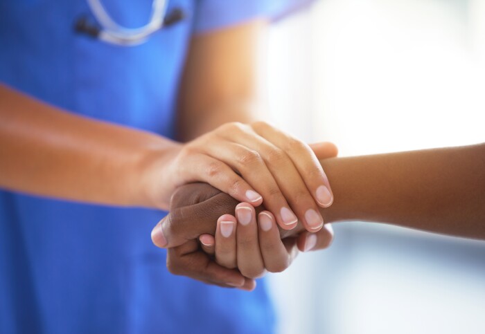 Medical staff holding hand of patient
