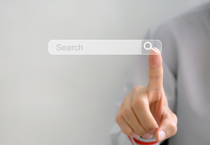 A person pressing a touchscreen button for an internet search bar.