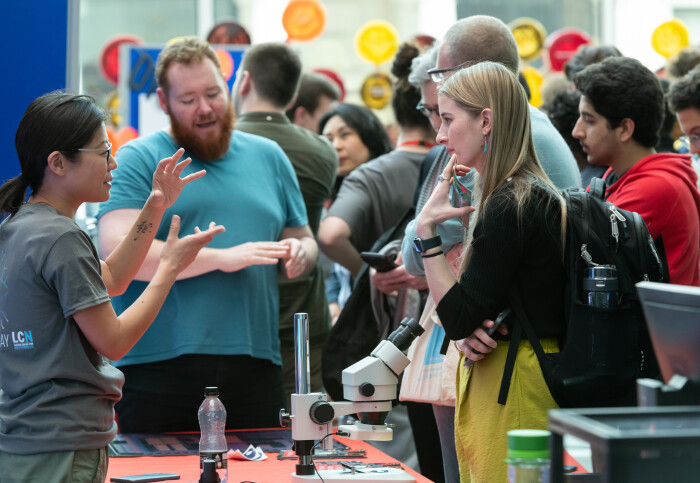 A researcher talking to an attendee at the Quantum Leaps event