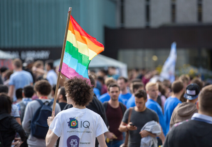 student carrying rainbow Pride flag at Fresher's Fair