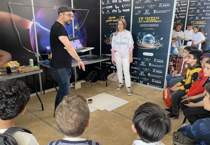 Scientific animator explaining experiment to group of children