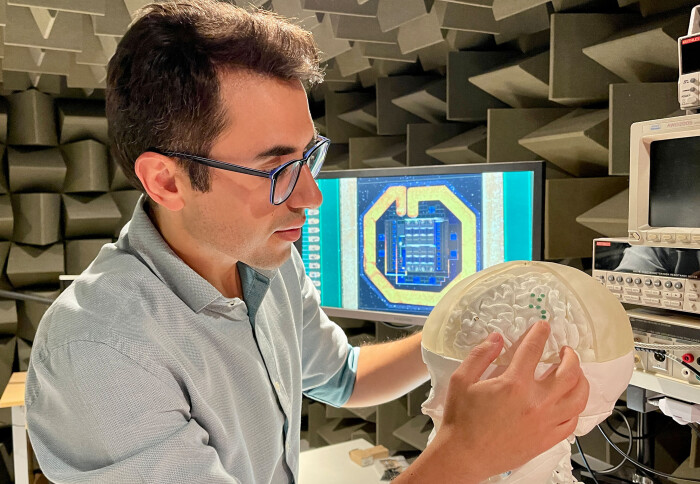 Dr Dorian Haci, CEO of MintNeuro, places electrodes on a model of a brain in the company's laboratory