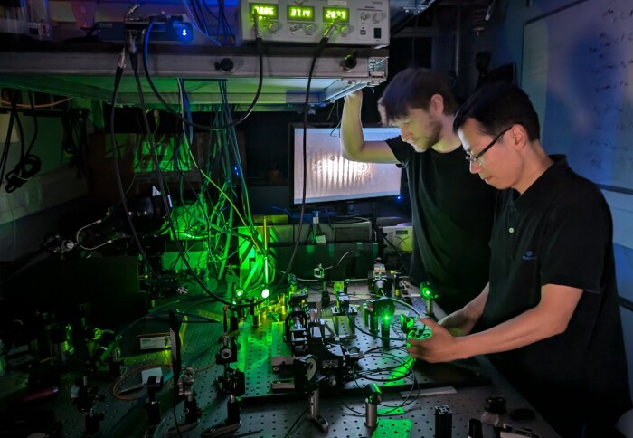 Dr Ross Schofield and Dr Ming Fu working at an optical table