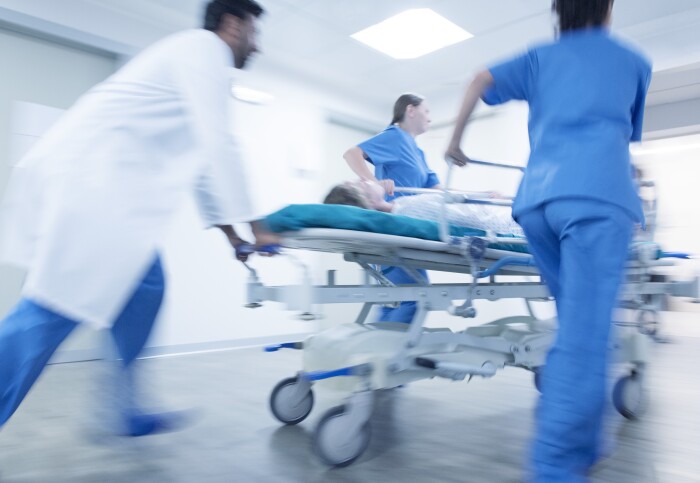 A patient is rushed through a hospital on a trolley