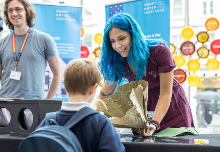 A person showing a small child how a something works using a prop