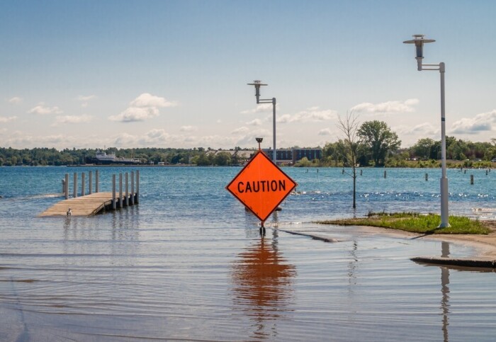 A flooded area with a caution sign in the water