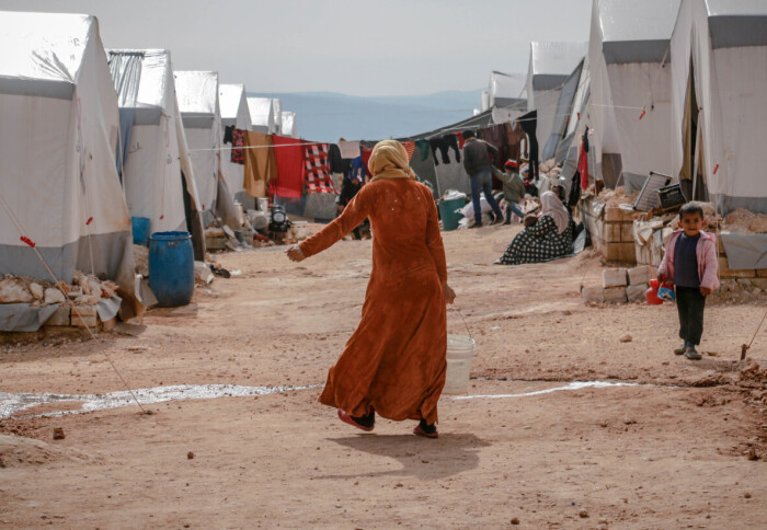 Anonymous woman walking in refugee camp