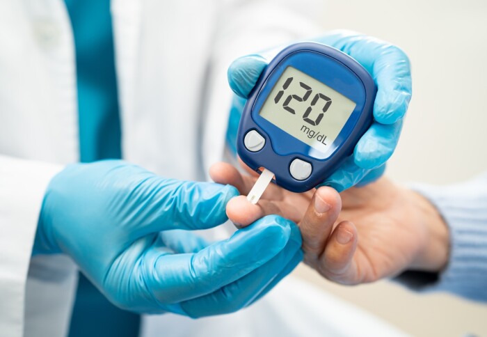 A health professional taking an insulin reading using a finger prick test