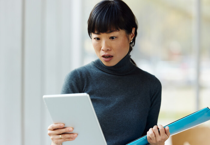 Surprised-looking businesswoman using touchpad