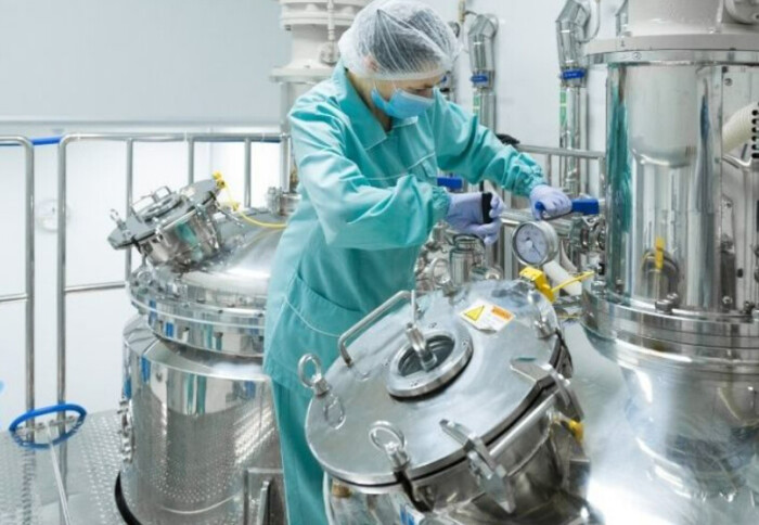 A person in a cap moving equipment in a lab.