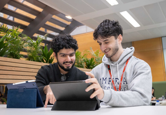 two students sat with tablets in a study space