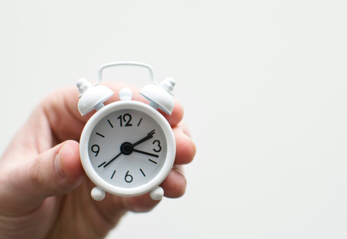 A person holding a clock up