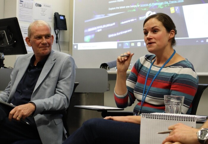 Two people speaking on a panel