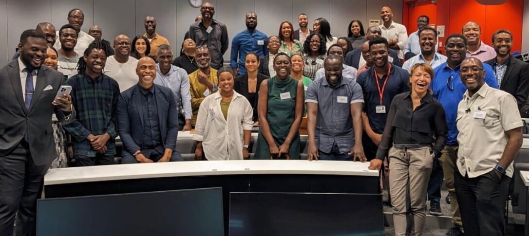 A large group of IBAN members pictured at a past event, grouped together in a lecture theatre smiling 