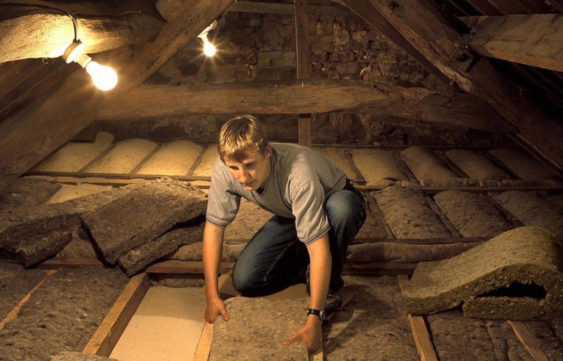 worker installing roof-insulation material from sheep's wool