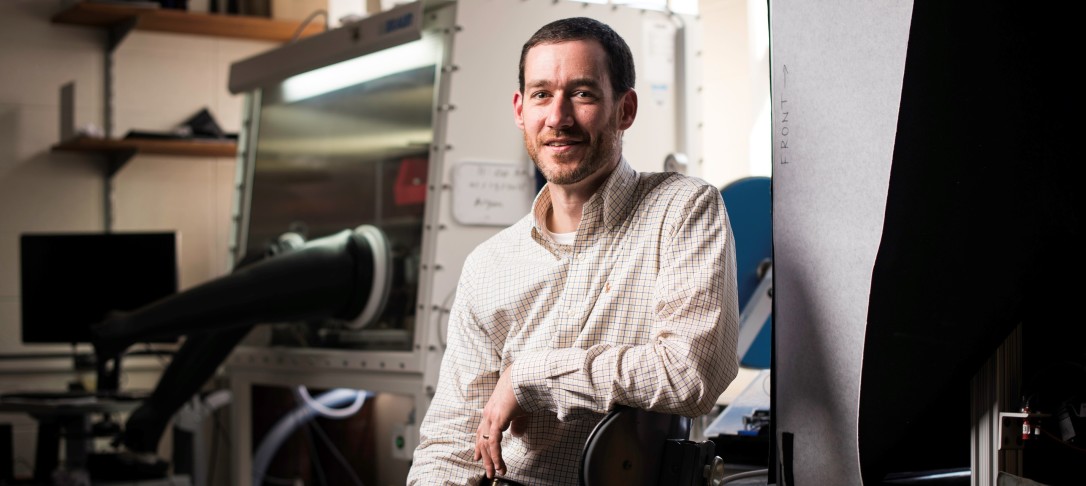 Portrait of Dr Doug Kelley. He is sat in a mechanical engineering laboratory. 