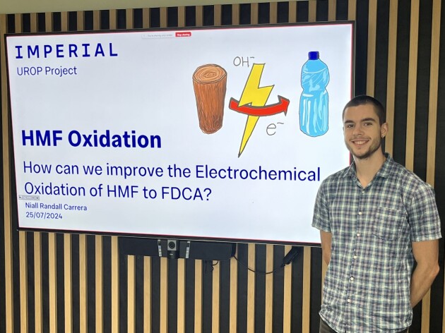 Niall Randall Carrera standing beside a presentation on HMF Oxidation