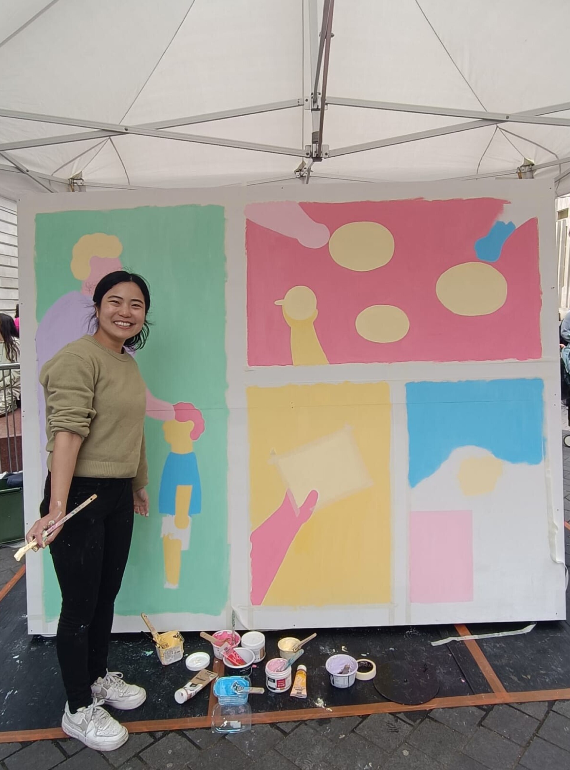 Artist SHIO next to her mural painting inspired by the Helix Centre’s Healthy Ageing project