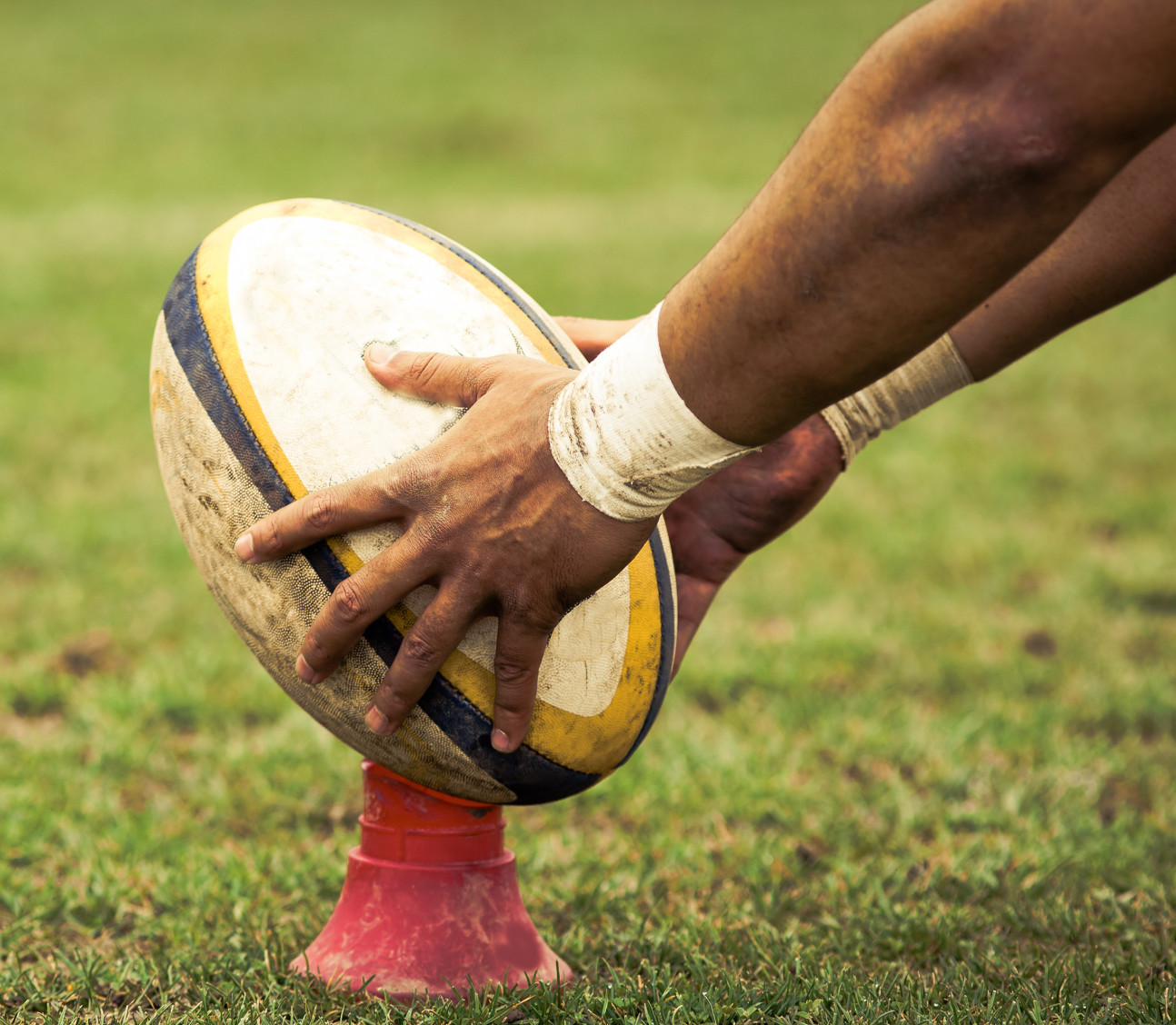 Photo of a rugby ball atop a tee