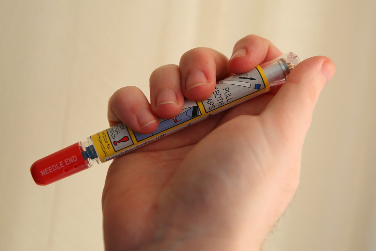 A hand holding an EpiPen