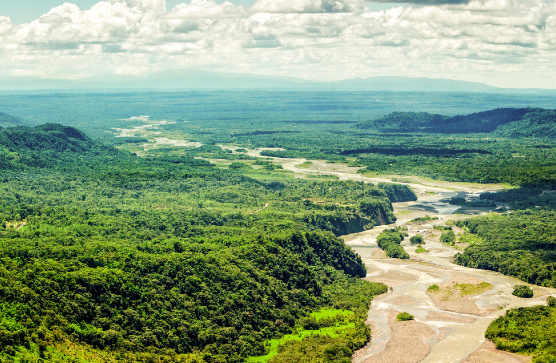 Aerial view of a wide river in a forested landscape