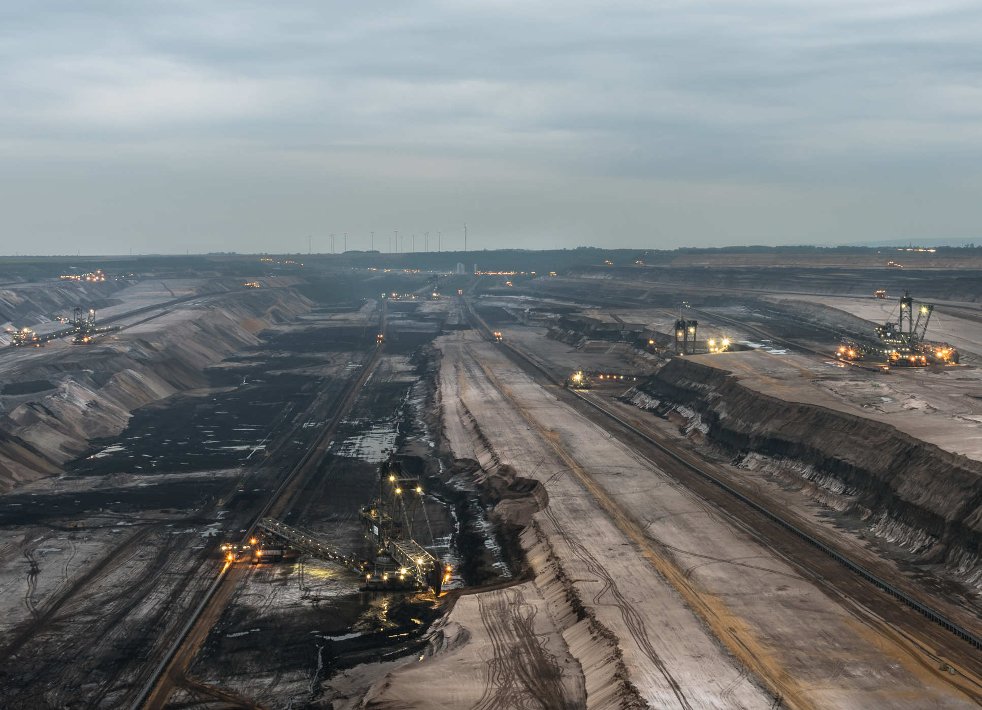 Open-pit coal mine covering a large surface area with heavy machinery
