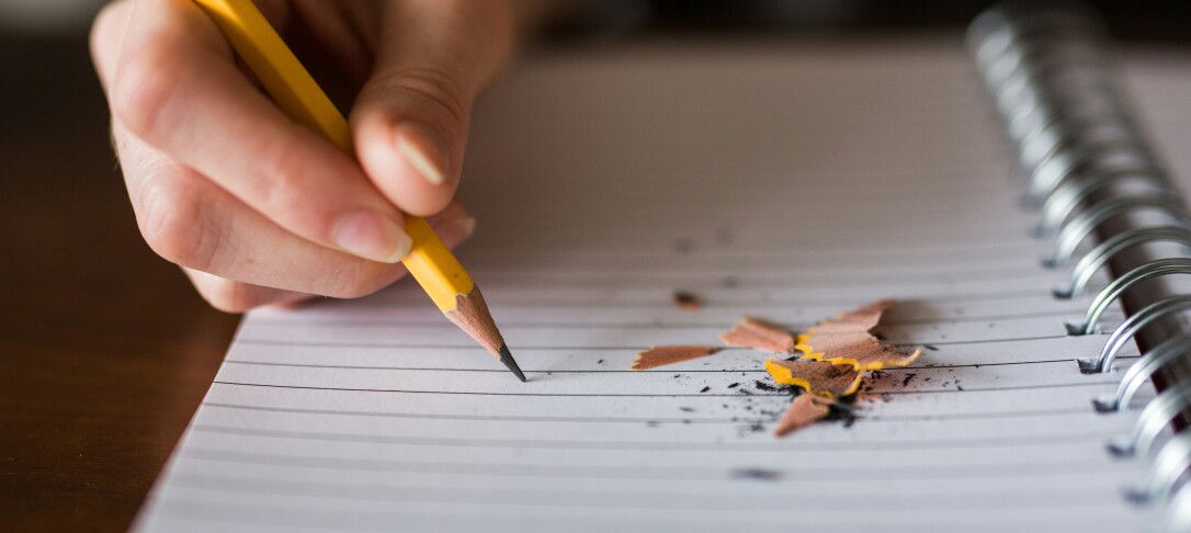 person writing on a piece of paper