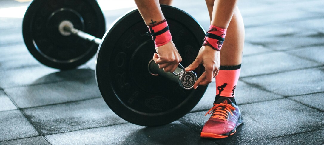 Woman adding weights to barbell