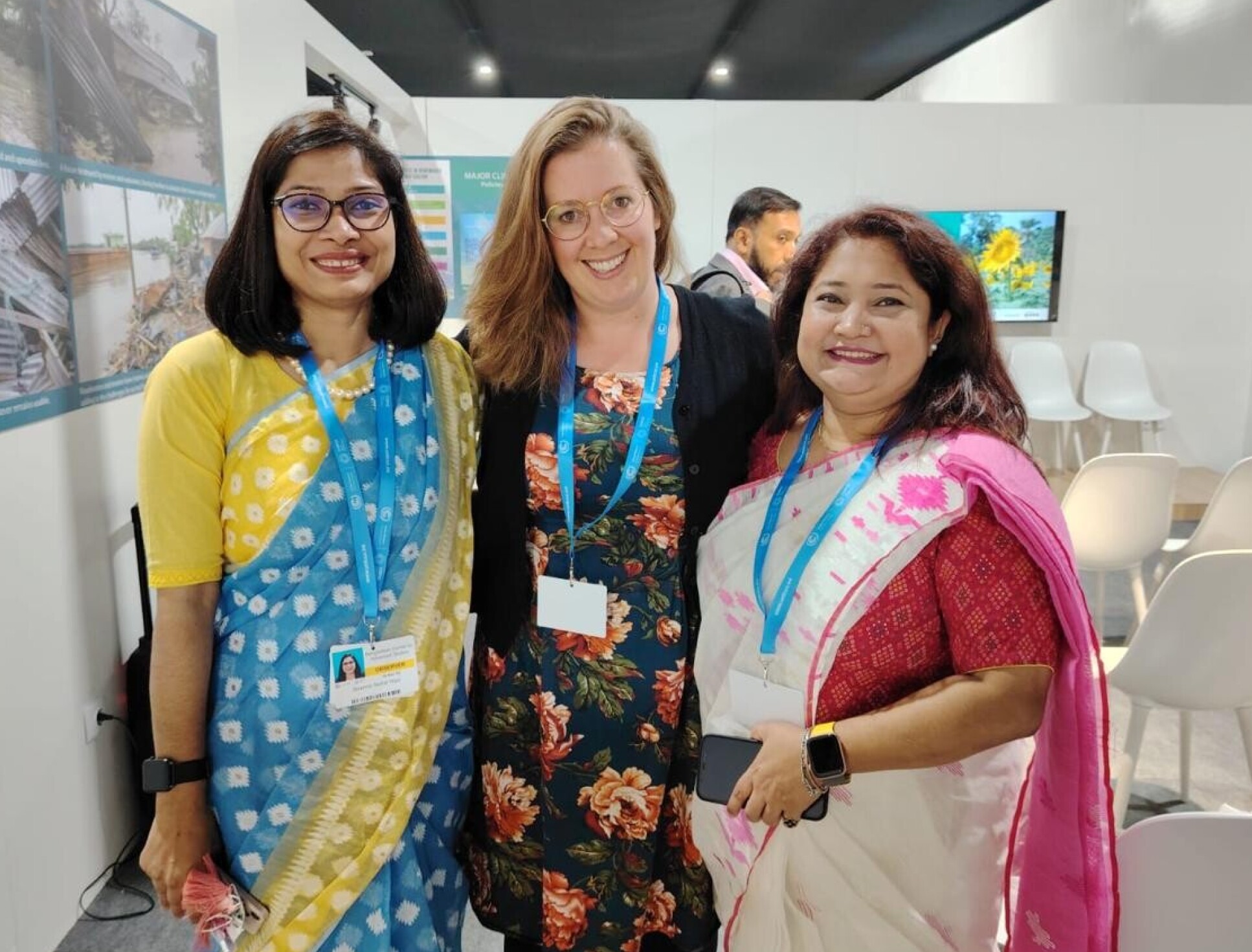 Emma Lawrance with representatives from Bangladesh in traditional dress at COP29.