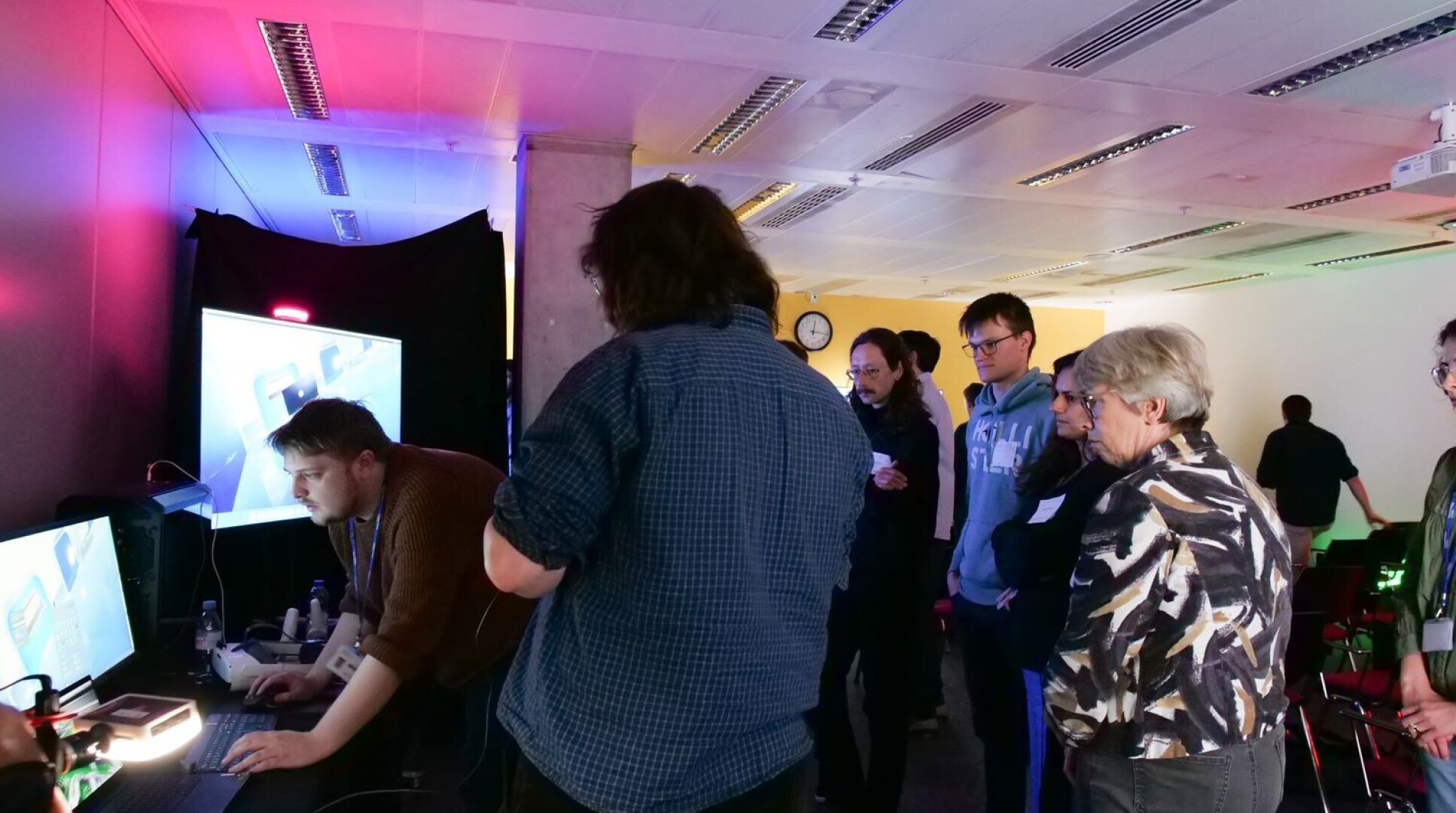 Delegates gather around an immersive learning experience on a digital screen