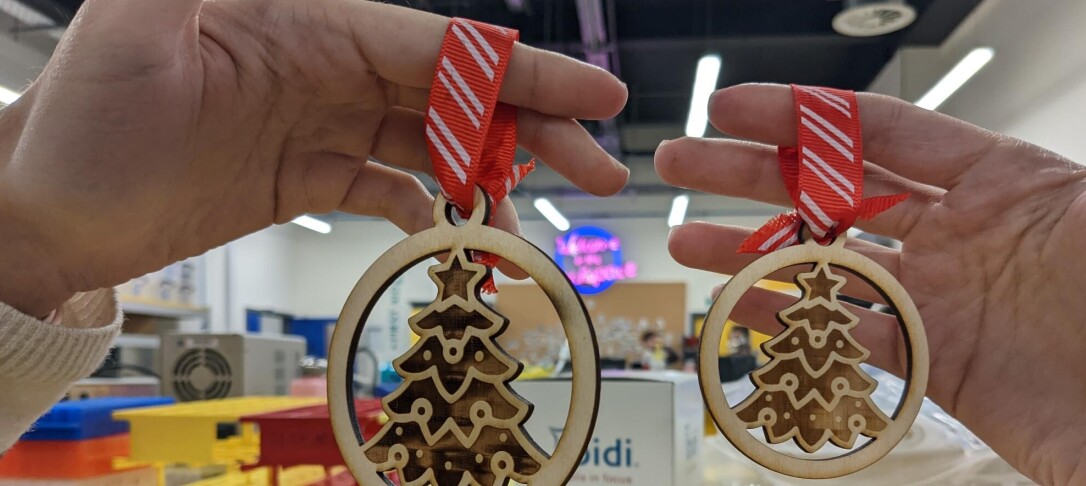 two laser cut christmas baubles with ribbon, christmas tree engraved on them