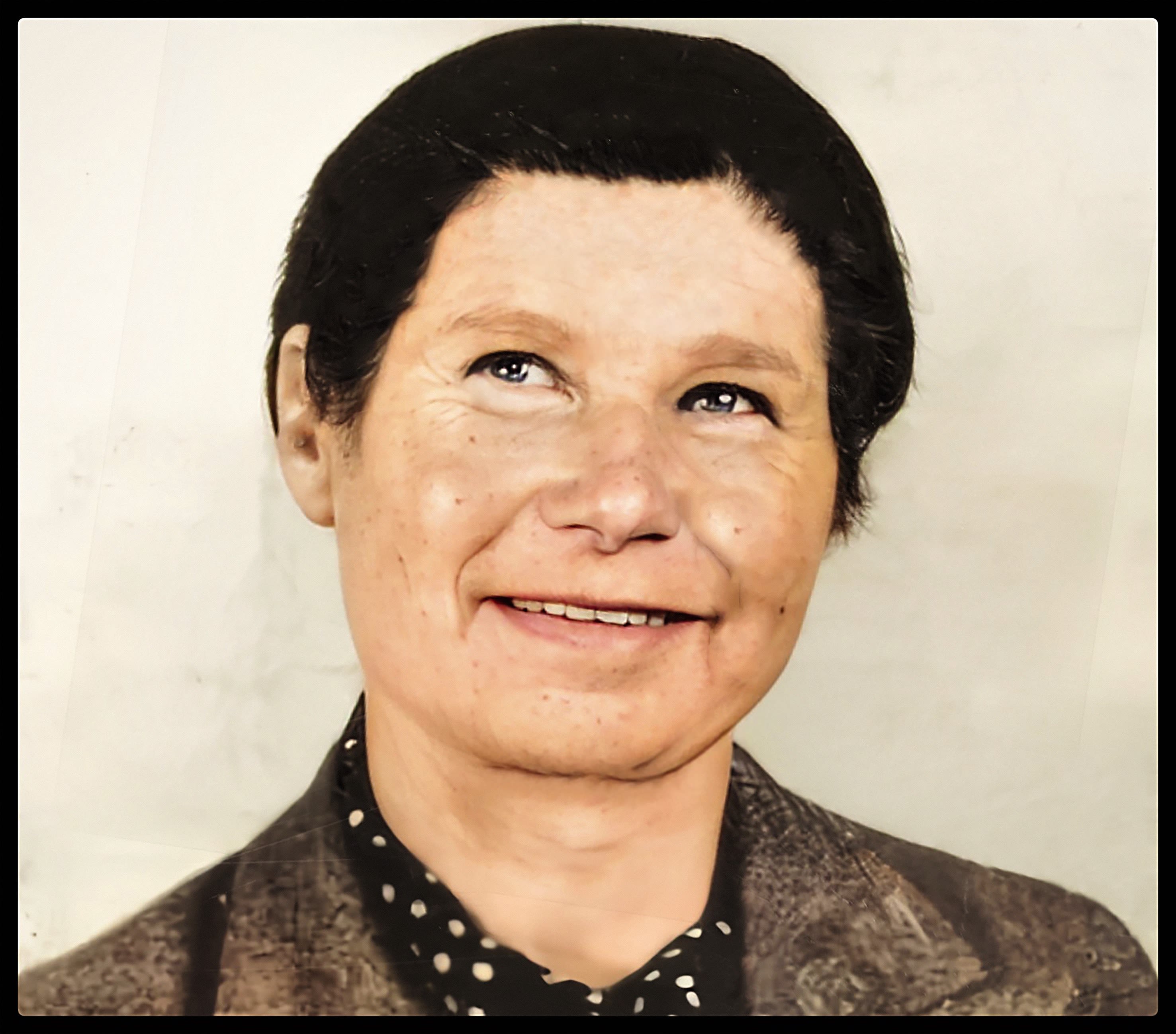 An image of Constance Tipper smiling. Originally a black and white photo, the artist has used computer technology to make this a colour photograph.