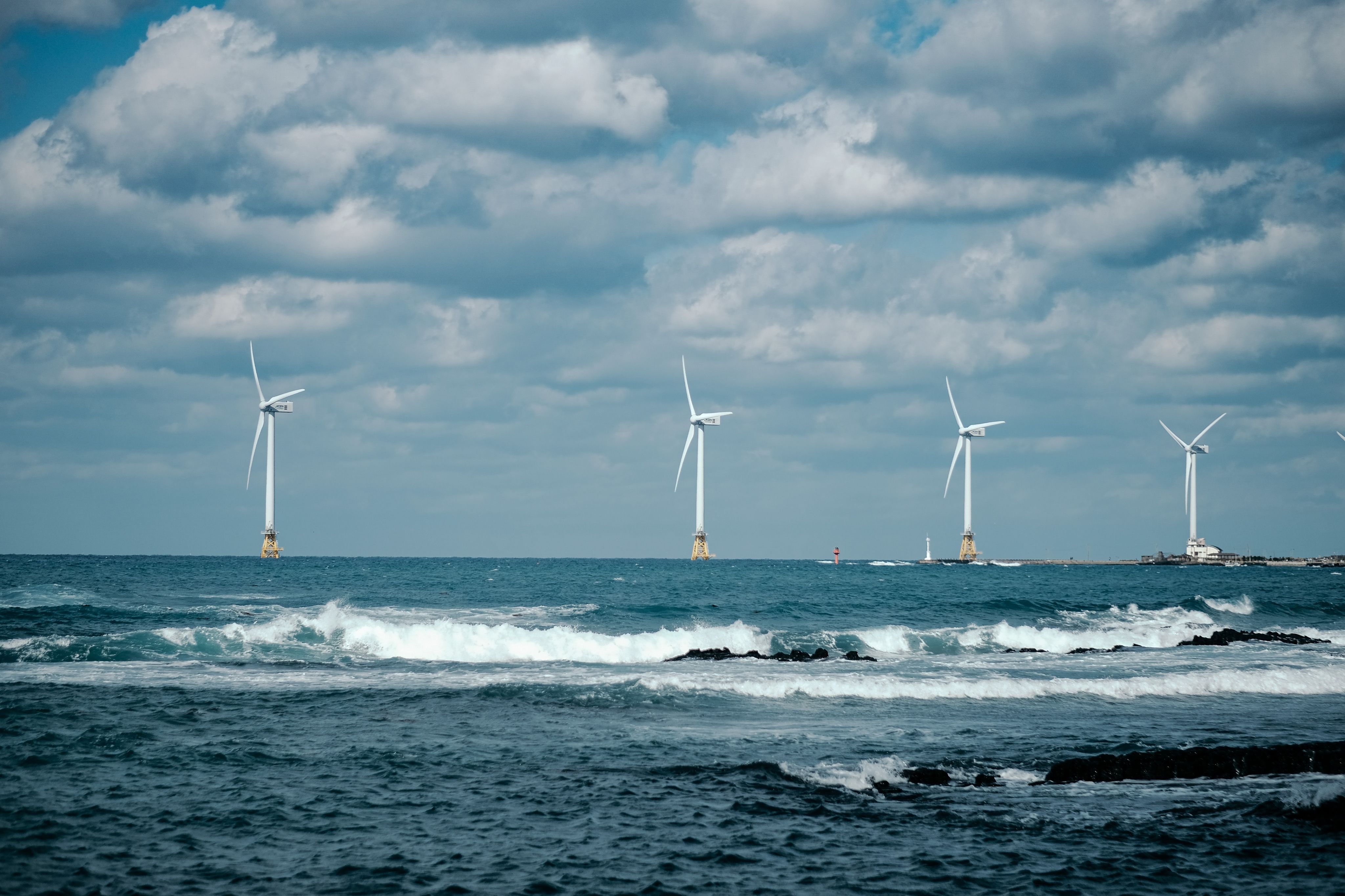 offshore white wind turbines during daytime