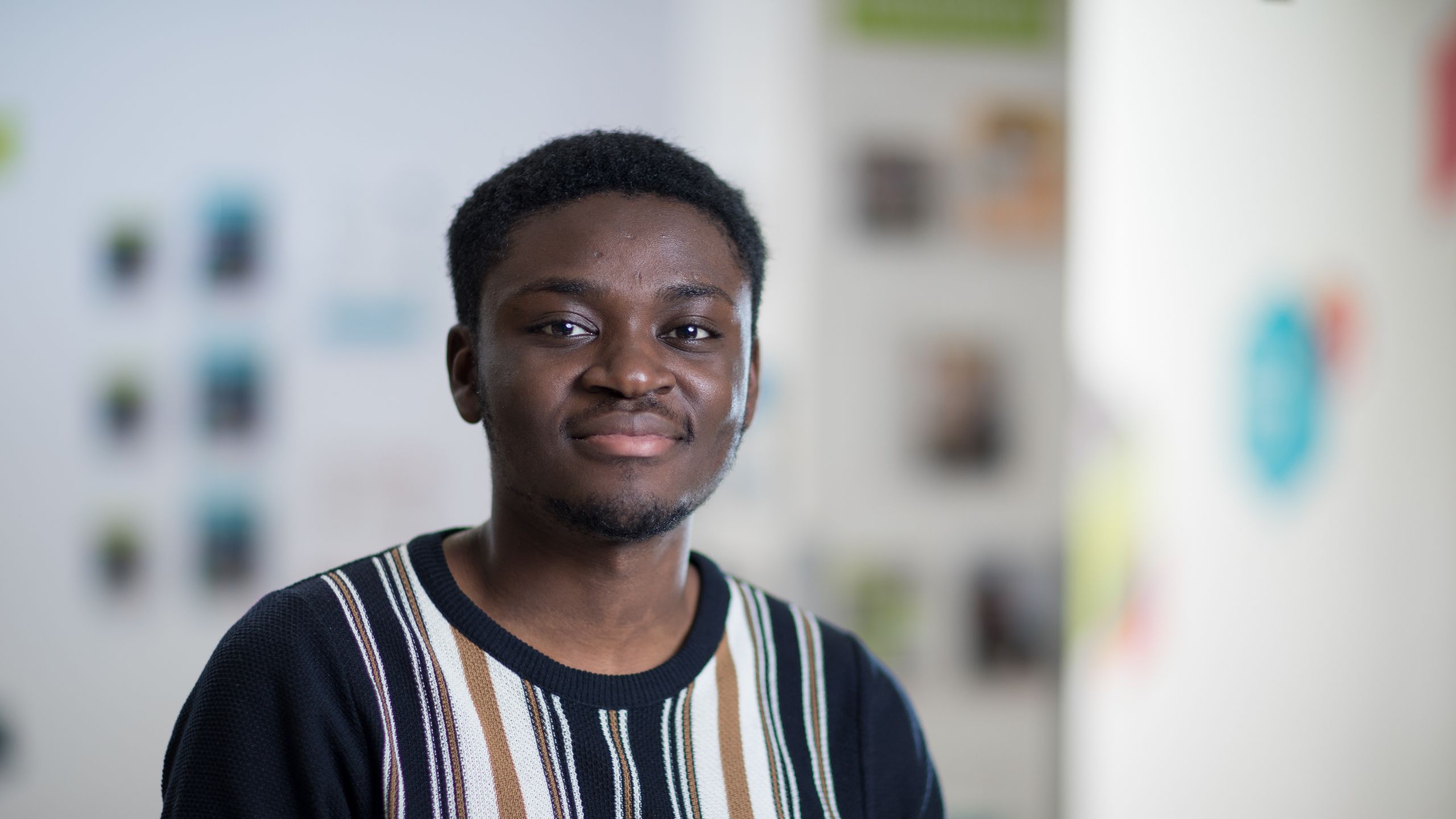 A photo of Abeku Koomson in front of a presentation stand.