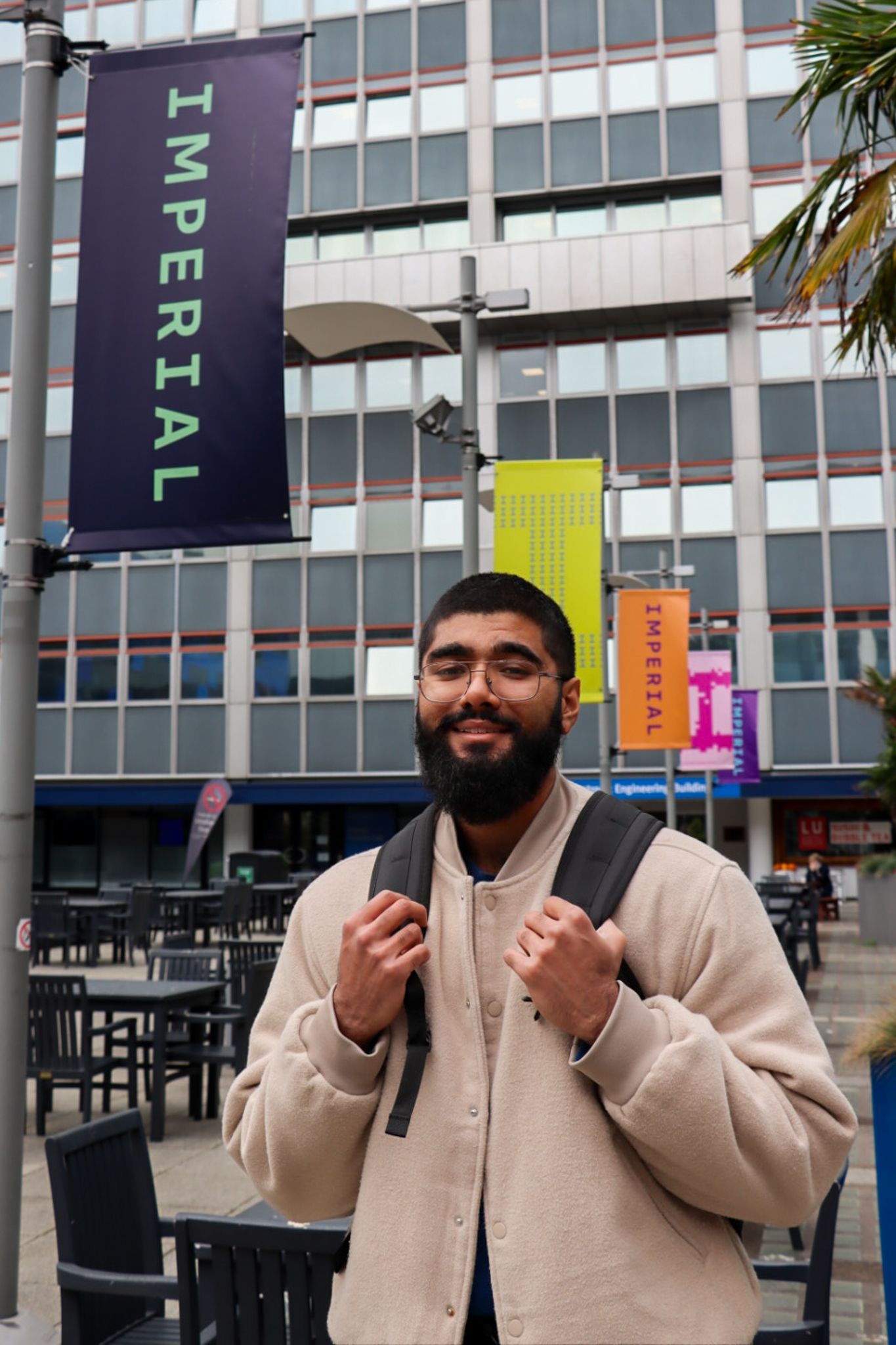 Haaris smiling at camera with Imperial pole banners in the background