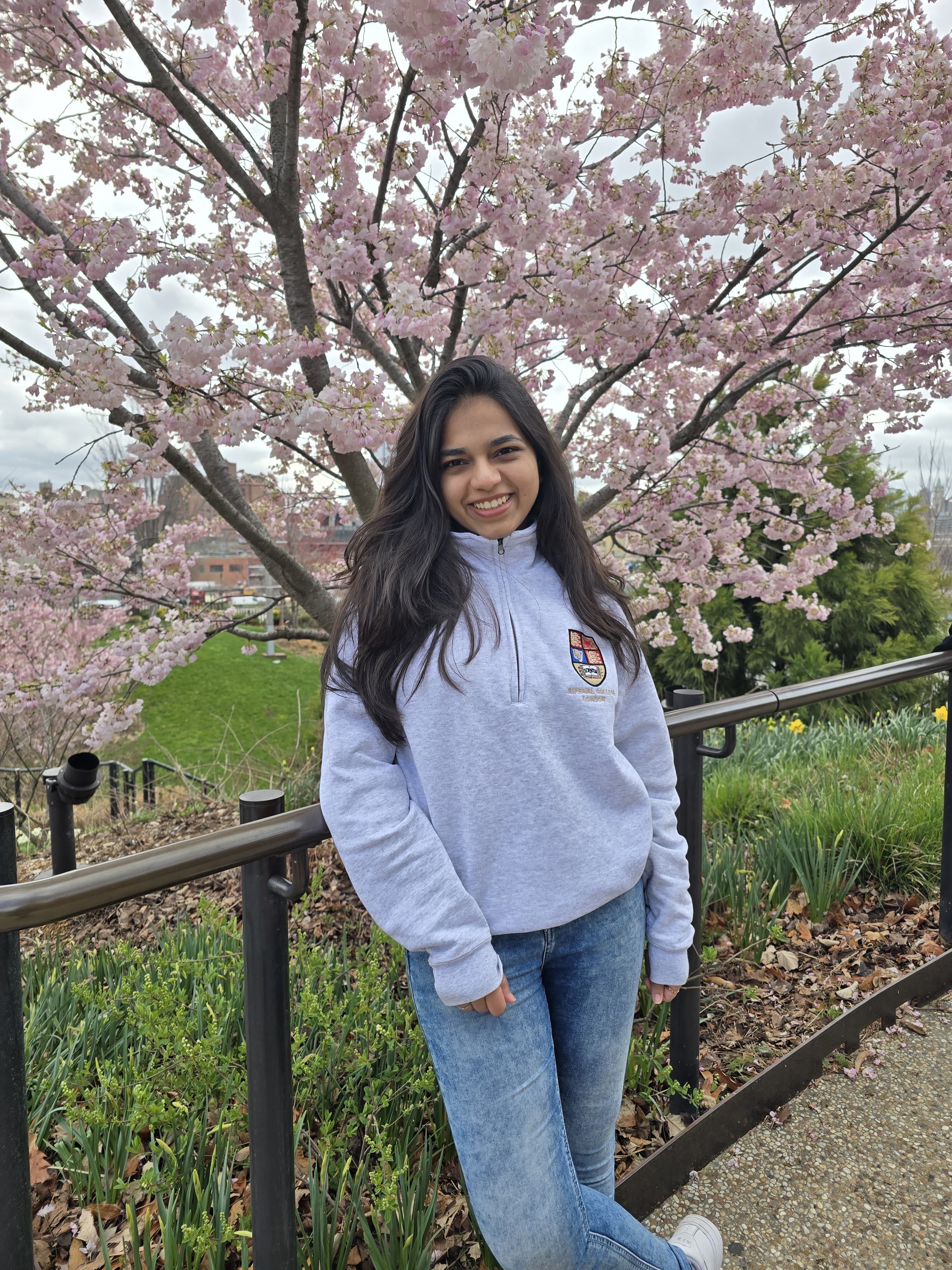 Vritee standing in front of a cherry blossom tree