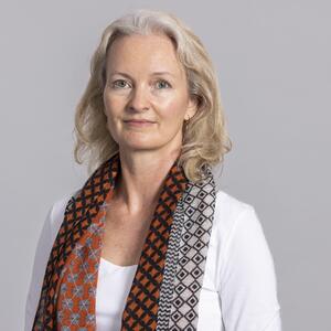 Picture of Pernille Holtedahl wearing a white top and colourful scarf around her neck. 