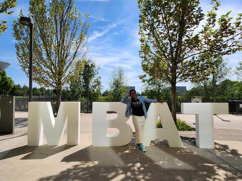 Student poses with MBAT sign in Paris