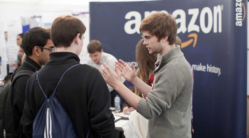 A student employer fair with a black and white Amazon backdrop in background