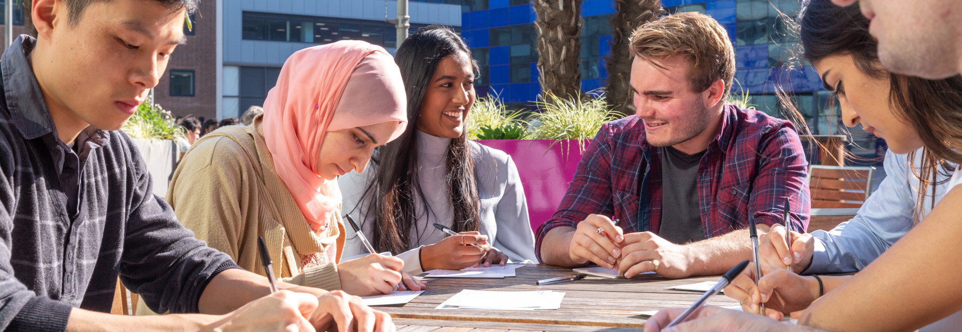 Students sat at desks on Dalby Court, working in the sunshine 