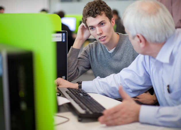 Student and tutor in conversation at a computer
